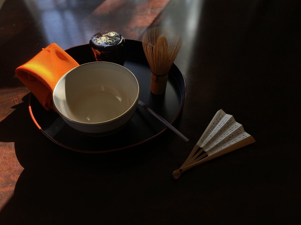 静謐な光の中に置かれた茶道具一式。茶筅と茶碗が作り出す陰翳が、千利休の教えである「独服（どくふく）」と「わびさび」の精神美を表している。撮影：写真家 魚住心（Leica）