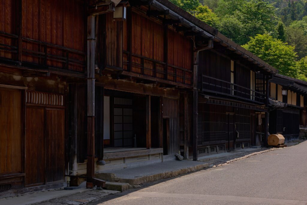 江戸時代の面影を色濃く残す宿場町・妻籠宿の古い木造の家並み。深く美しい木肌の格子戸と出桁造りの建物が並び、柔らかな日差しと静かな影が演出する日本の伝統美。